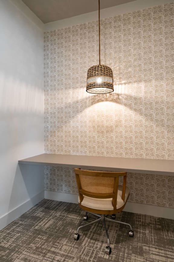 a desk and a chair in a room with a lamp