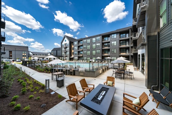 an outdoor patio with tables and chairs and a swimming pool
