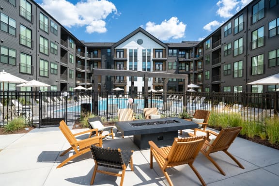 an outdoor patio area with a fire pit and chairs