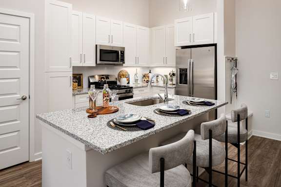 A kitchen with a granite countertop and white cabinets.