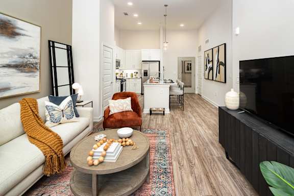 A living room with a white couch, a coffee table, and a large painting on the wall.
