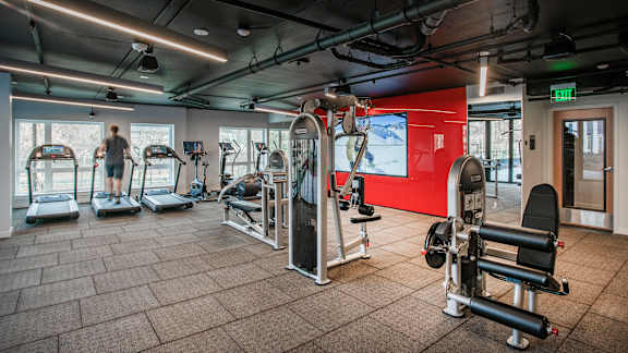 A gym with a variety of equipment including treadmills, weights, and exercise machines.at Axle, Seattle Washington