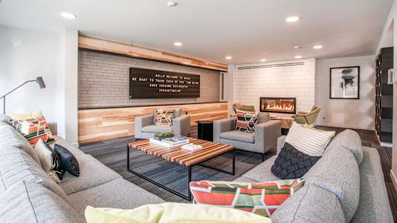A living room with a grey couch, a coffee table, and a wooden wall.at Axle, Seattle, WA 98119