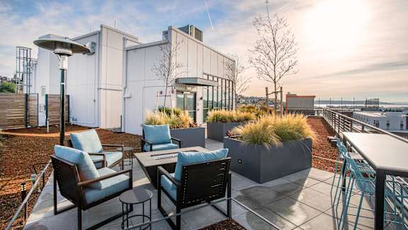 A patio with a table and chairs overlooking a body of water.at Axle, Washington, 98119