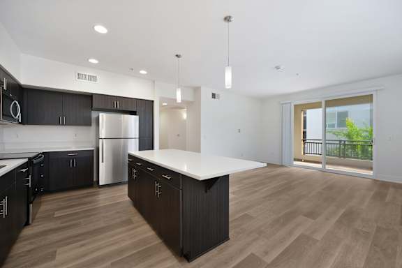 A modern kitchen with dark brown cabinets and a white island.