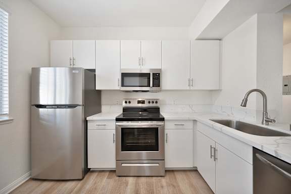 A modern kitchen with stainless steel appliances and white cabinets.
