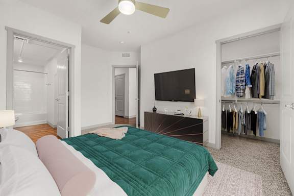 A bedroom with a bed, a television, and a closet.