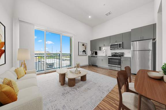A modern kitchen and living room with a view of the outside.