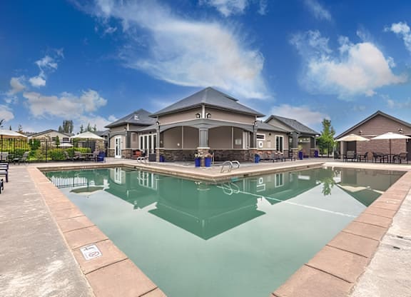 A large swimming pool with a building in the background.