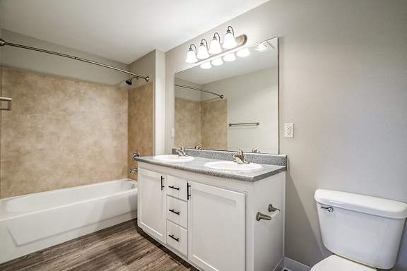 A bathroom with a white toilet, sink, and bathtub.