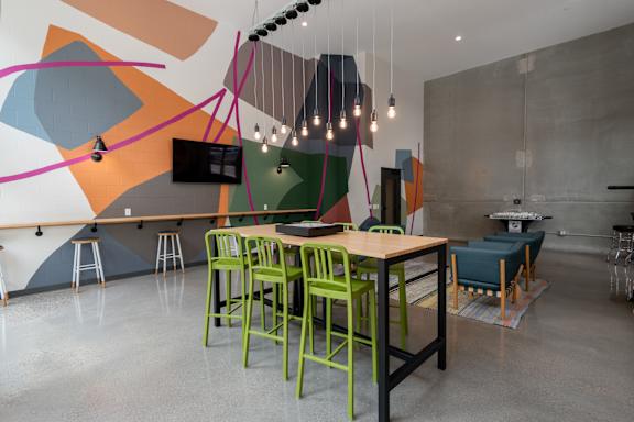 A modern dining area with a wooden table and green chairs.