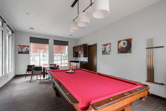 A pool table is in the middle of the room.