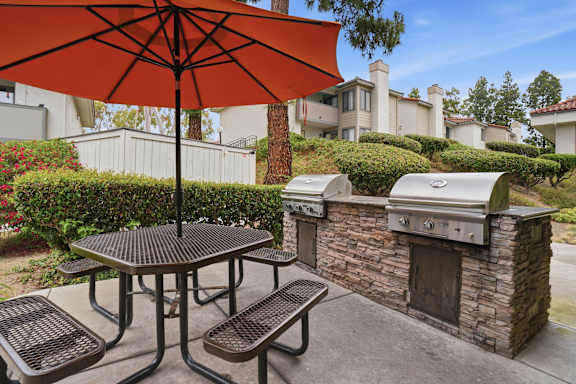 A patio with a table, chairs and an umbrella.