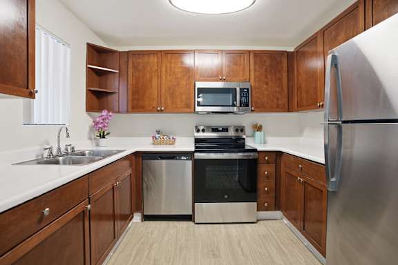 A kitchen with wooden cabinets and stainless steel appliances.