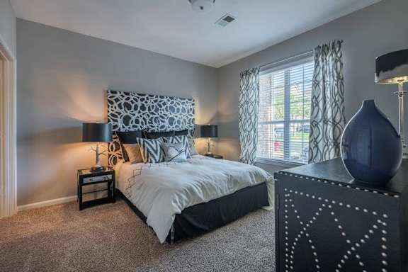 A bedroom with a large bed and a decorative pillow.