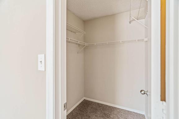 A white closet with a door and a light switch.