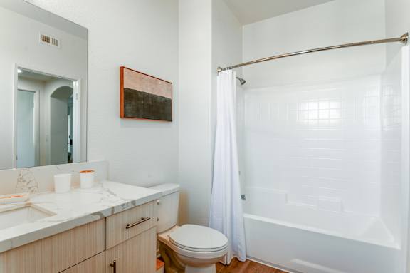 A bathroom with a toilet, sink, and shower.
