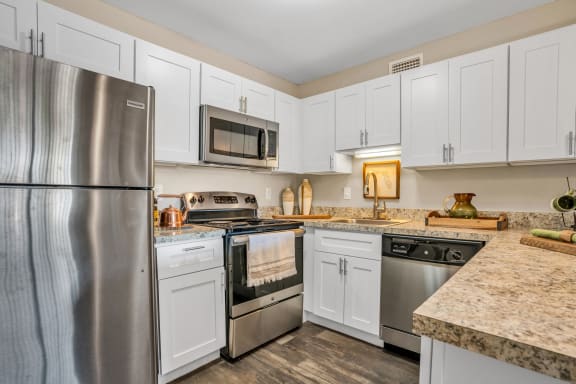 a kitchen with white cabinets and stainless steel appliances  at Castilian Apartments, Orlando, FL, 32839