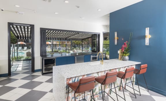 a kitchen with a marble counter top and chairs