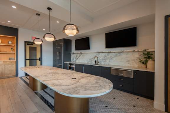 A modern kitchen with a marble countertop and a curved island.
