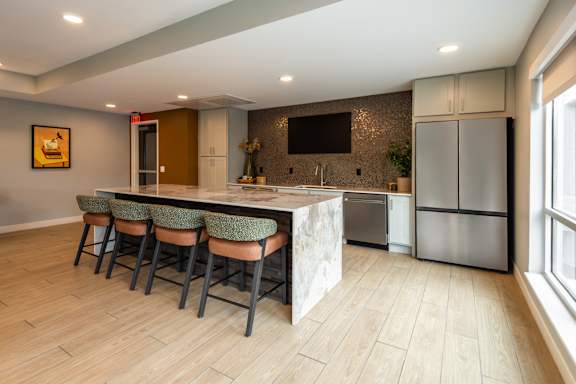 A kitchen with a bar area and stools.