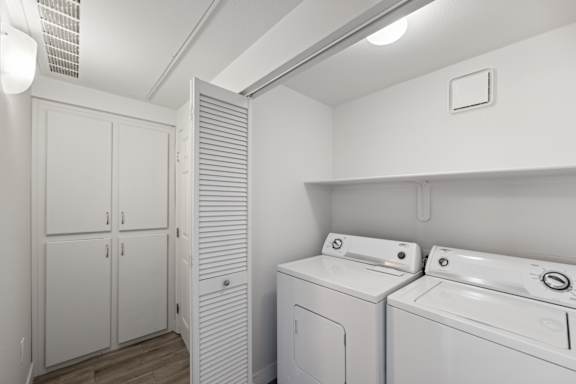 A white laundry room with a washer and dryer.