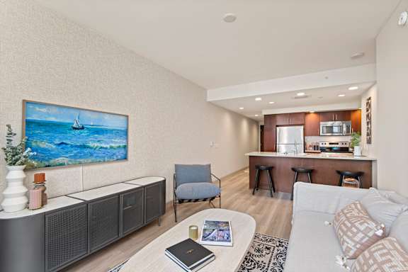 A modern living room with a large painting of a sailboat on the wall.