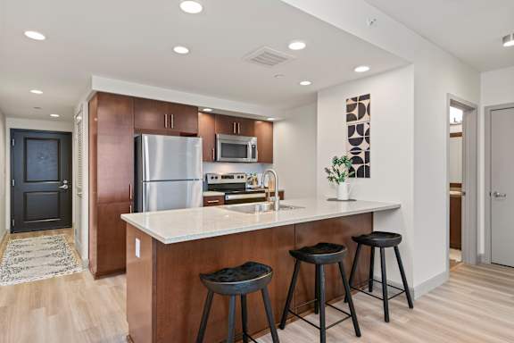 A kitchen with a white countertop and a refrigerator.