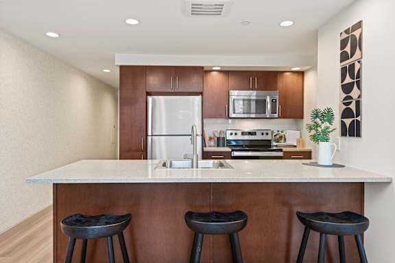 A kitchen with a white countertop and brown cabinets.