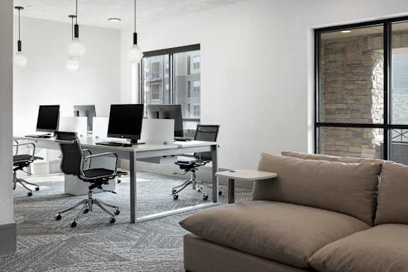 A modern office space with a couch, chairs, and desks.