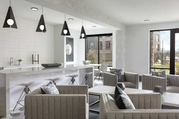 A modern living room with grey couches and a white kitchen.