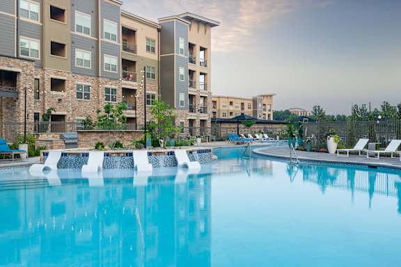 A large swimming pool in front of apartment buildings.