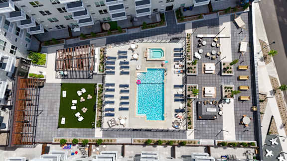 A pool and patio area in a courtyard surrounded by buildings.