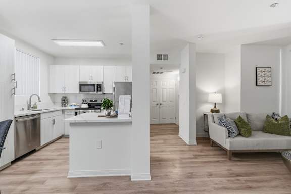 A modern kitchen with a dining area and a living room.