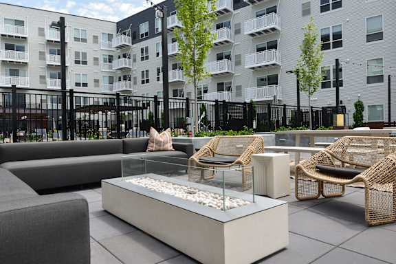 A modern outdoor seating area with a white planter in the center.
