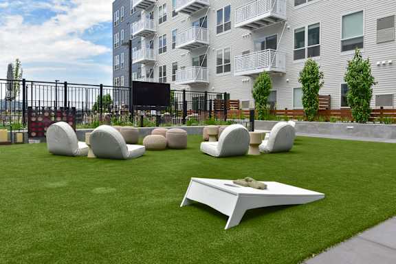 A white sculpture sits on a green lawn in front of a building.