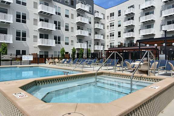 A large swimming pool in front of apartment buildings.
