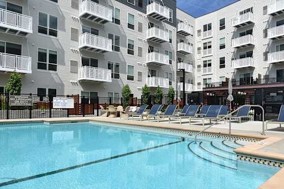A large swimming pool in front of apartment buildings.