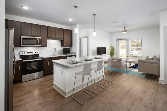a kitchen and living room with an island and a table with chairs