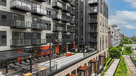 A modern apartment complex with balconies and a pool.