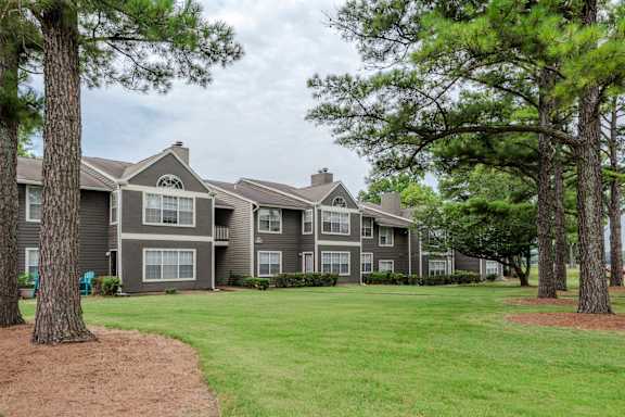 Apartment complex with trees in front.