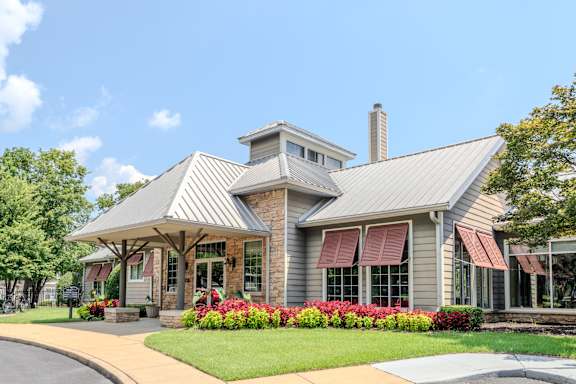 A house with a grey roof and a red awning.