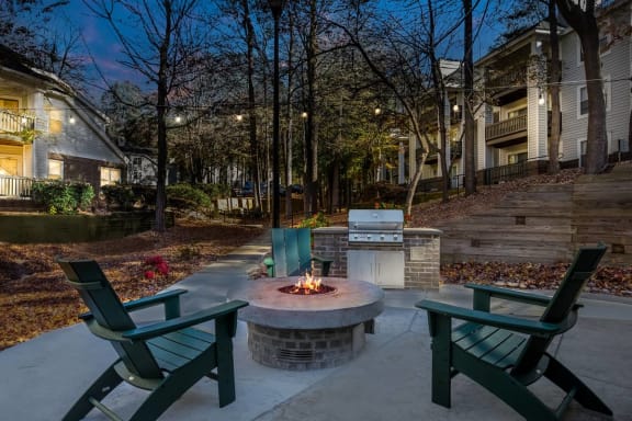 a backyard with a fire pit and chairs