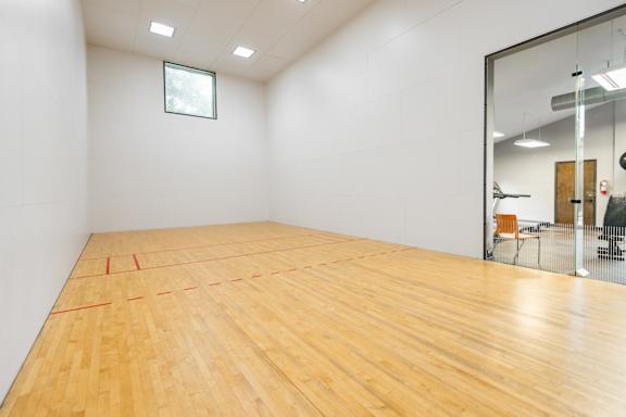 A room with wooden flooring and a glass wall.