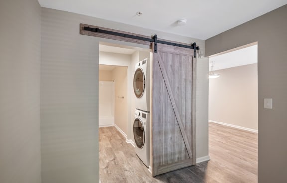a washer and dryer in a laundry room with a sliding barn door