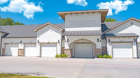 A large house with a garage door and a covered driveway.