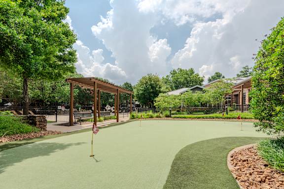 A miniature golf course with a flag on the green.