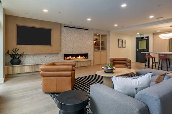 A modern living room with a fireplace and a flat screen TV mounted on the wall.