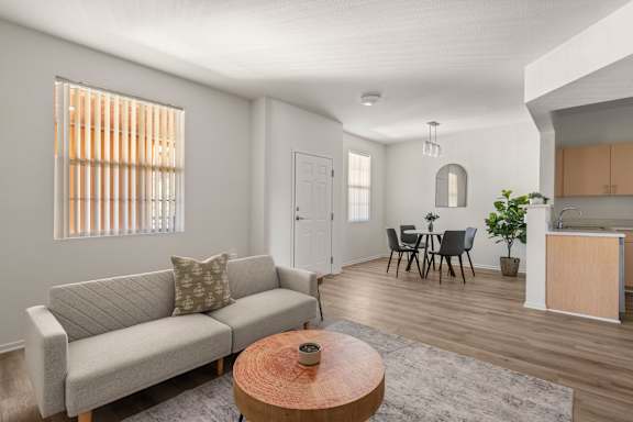 A living room with a grey couch and a wooden coffee table.
