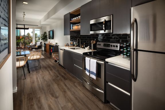 a kitchen with gray cabinets and stainless steel appliances at Burano, Long Beach